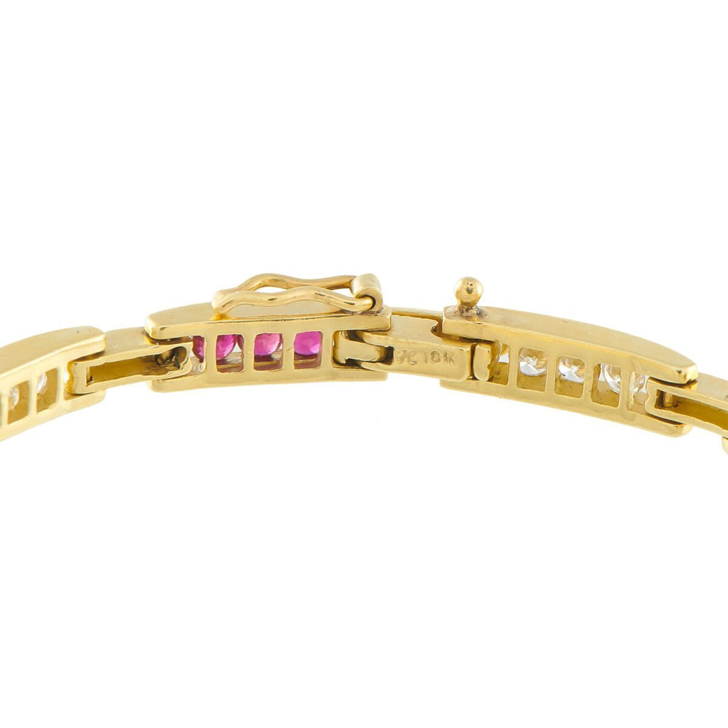Yellow gold bracelet hinge clasp detail with ruby and diamond row settings.