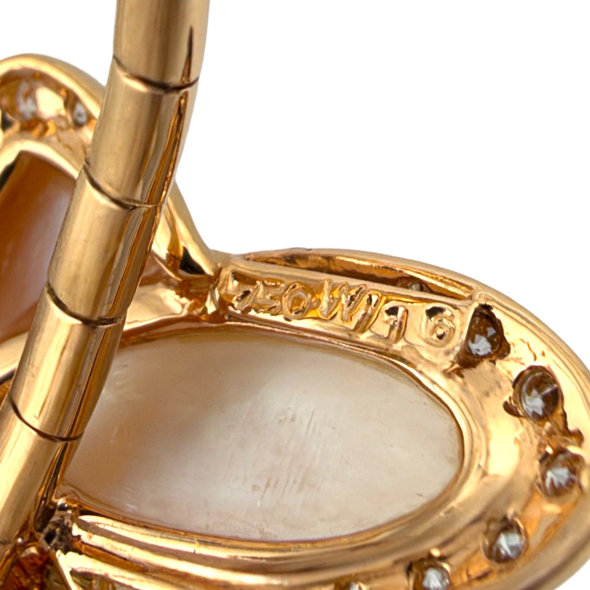 Rose gold bracelet close-up showing the back of a pearl inlay and diamond-set butterfly