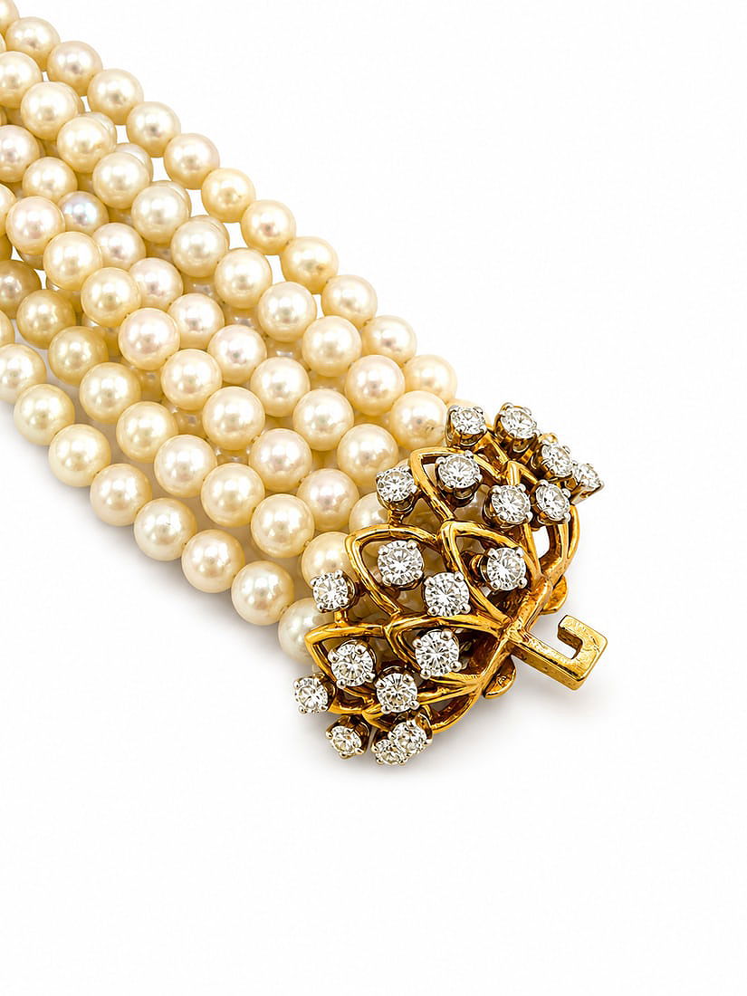 Pearl multi-strand bracelet with gold diamond clasp cluster, close-up view