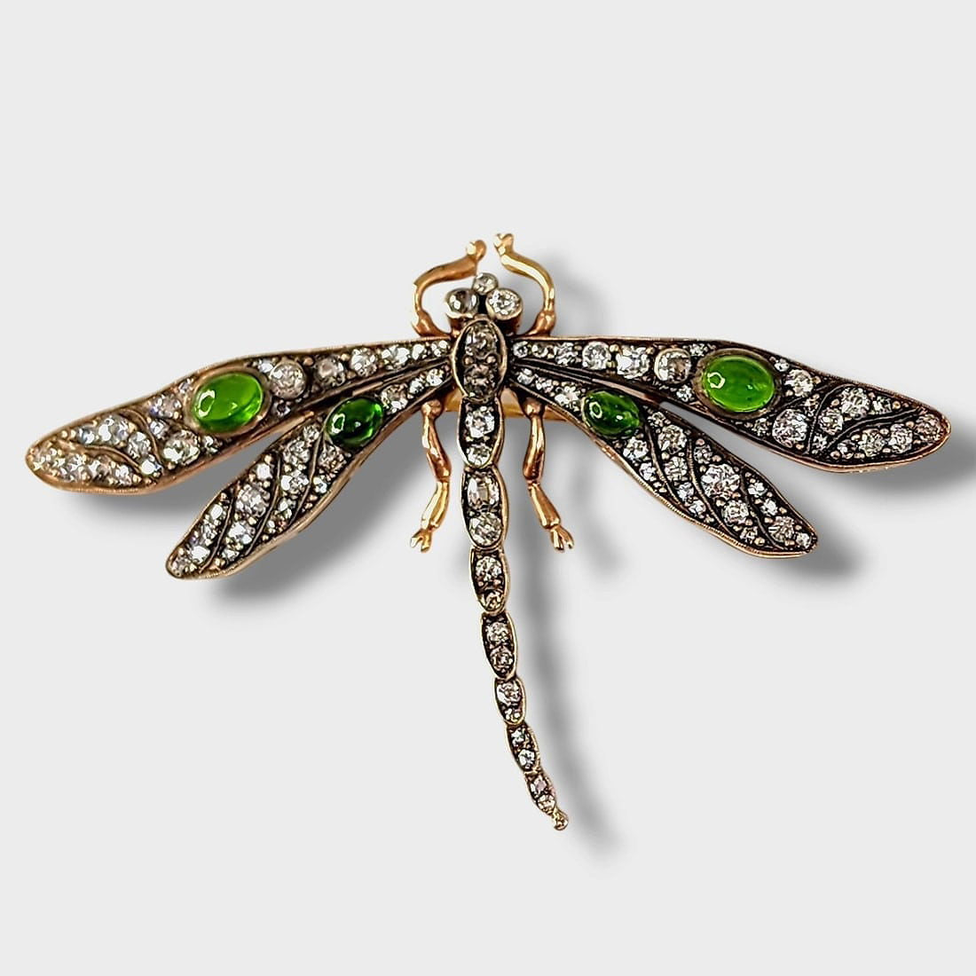 Dragonfly brooch with green enamel body and clear rhinestone wings, gold tone