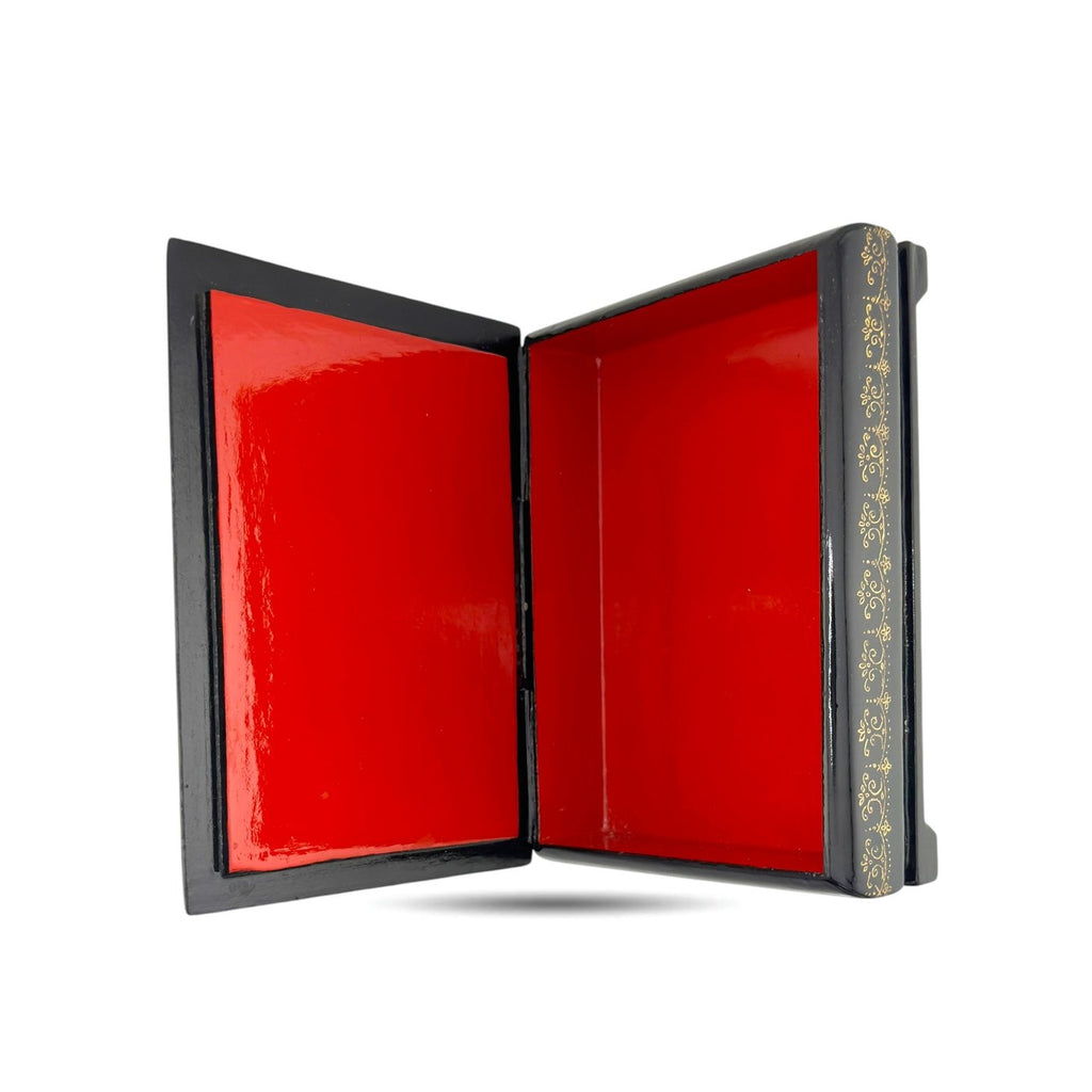 Black lacquer trinket box open to reveal glossy red interior panels