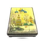 Black lacquer trinket box with church scene on lid and side, closed three-quarter view