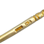 Close-up of antique-style spoon handle with gold hallmark stamps