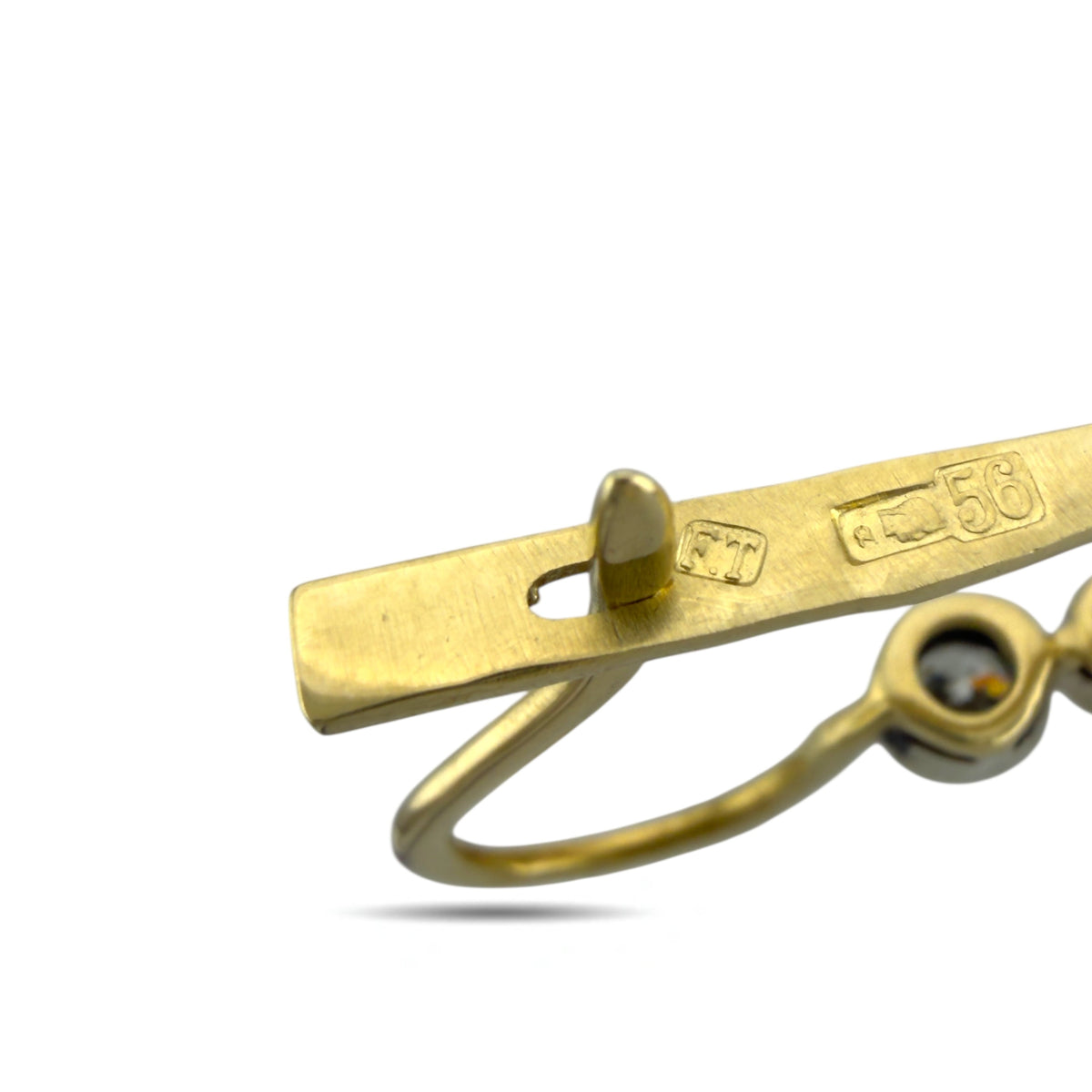 Close-up of gold earring hook and latch with engraved markings