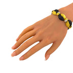 Angled view of the gold and black onyx bracelet worn on the wrist