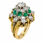 Yellow gold ring featuring round diamonds and green emeralds with raised prongs