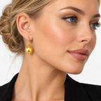18K yellow gold ball dangle earrings on ear with round polished spheres
