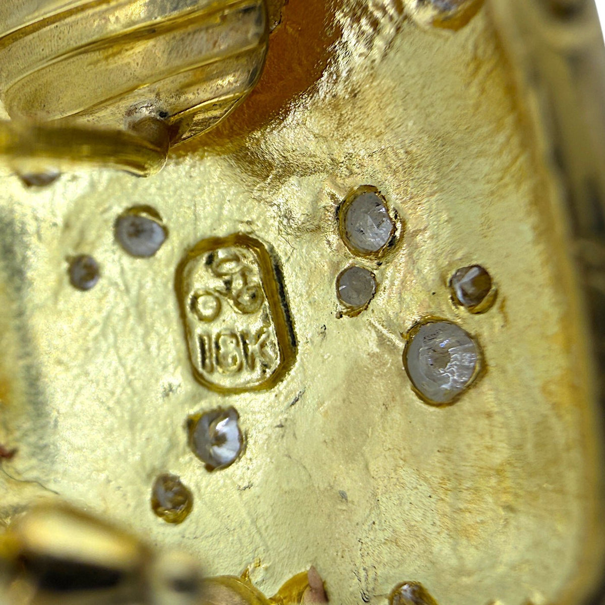 Close-up of yellow gold earring back with hallmark and small diamond settings