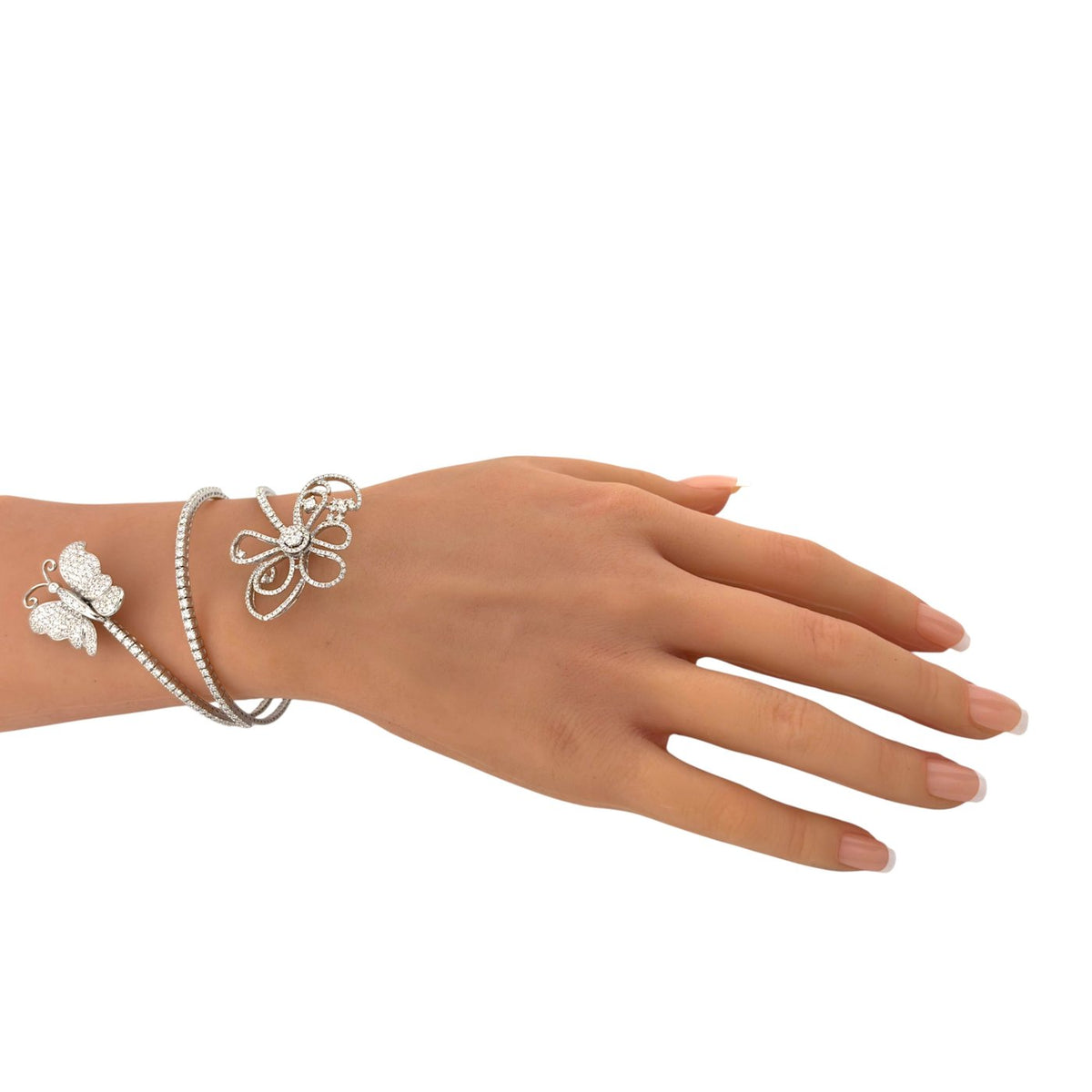 White gold diamond bracelet with butterfly and flower motifs, shown on the wrist