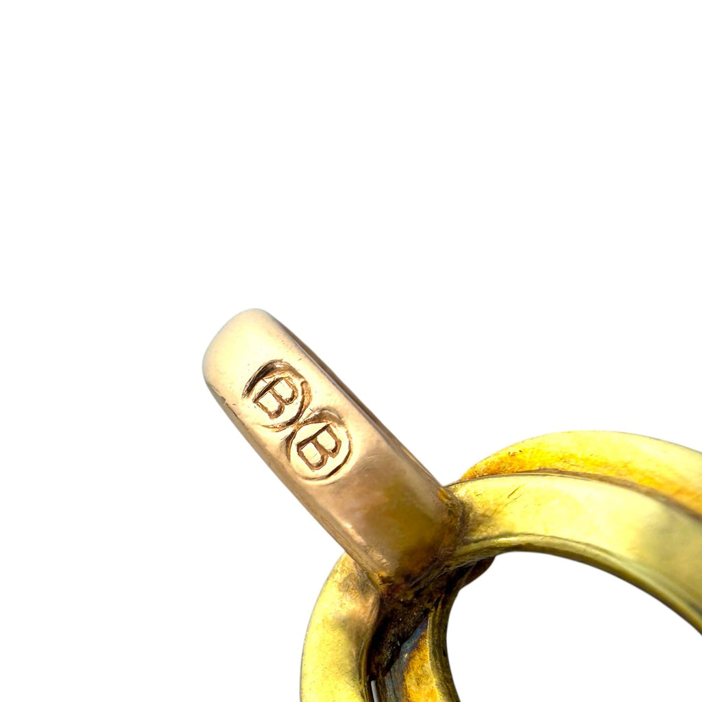 Close-up of gold tone clasp with engraved maker mark on link