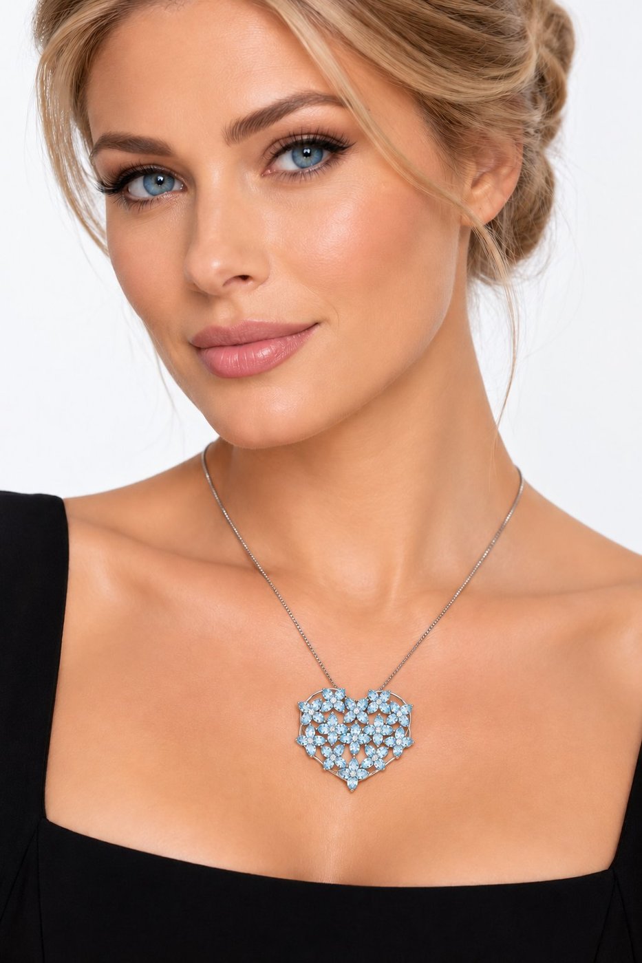 Blue heart gemstone necklace worn on neckline with diamond accents, thin silver chain