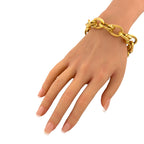 18K yellow gold textured oval link bracelet on wrist, glossy ribbed oval links