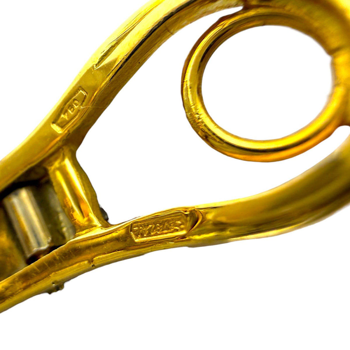 Gold earring clasp and hook close-up with engraved details