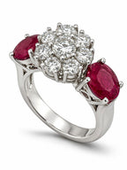 Platinum ring with diamond cluster and two oval ruby accents on the sides