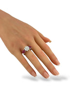 Platinum diamond and ruby ring worn on hand with round center stone