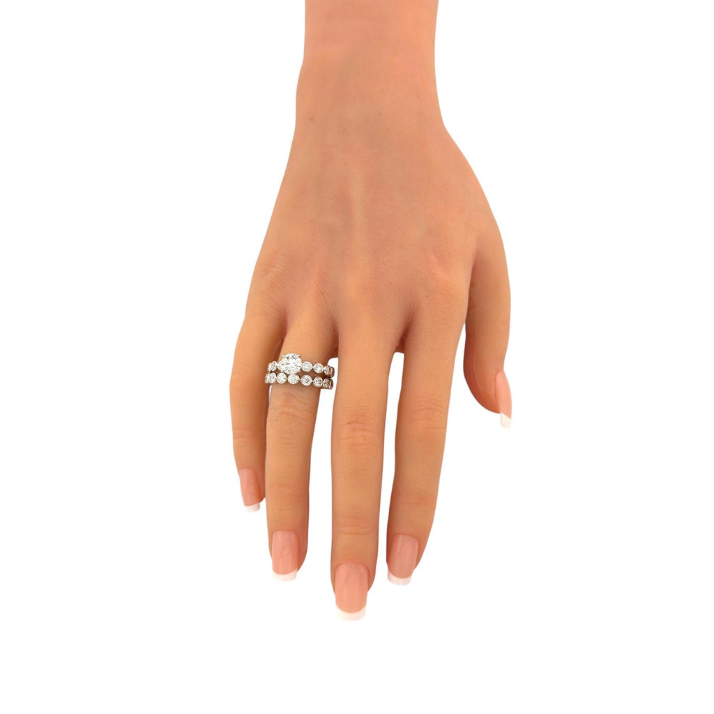 White gold diamond ring set worn on finger, small round stones on slim band