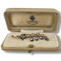 Rose gold lily brooch with dark diamond-like stones in open presentation case
