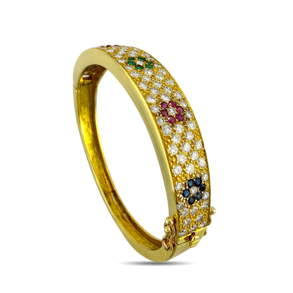 Yellow gold hinged cuff bracelet featuring diamond pave with colorful sapphire and ruby clusters