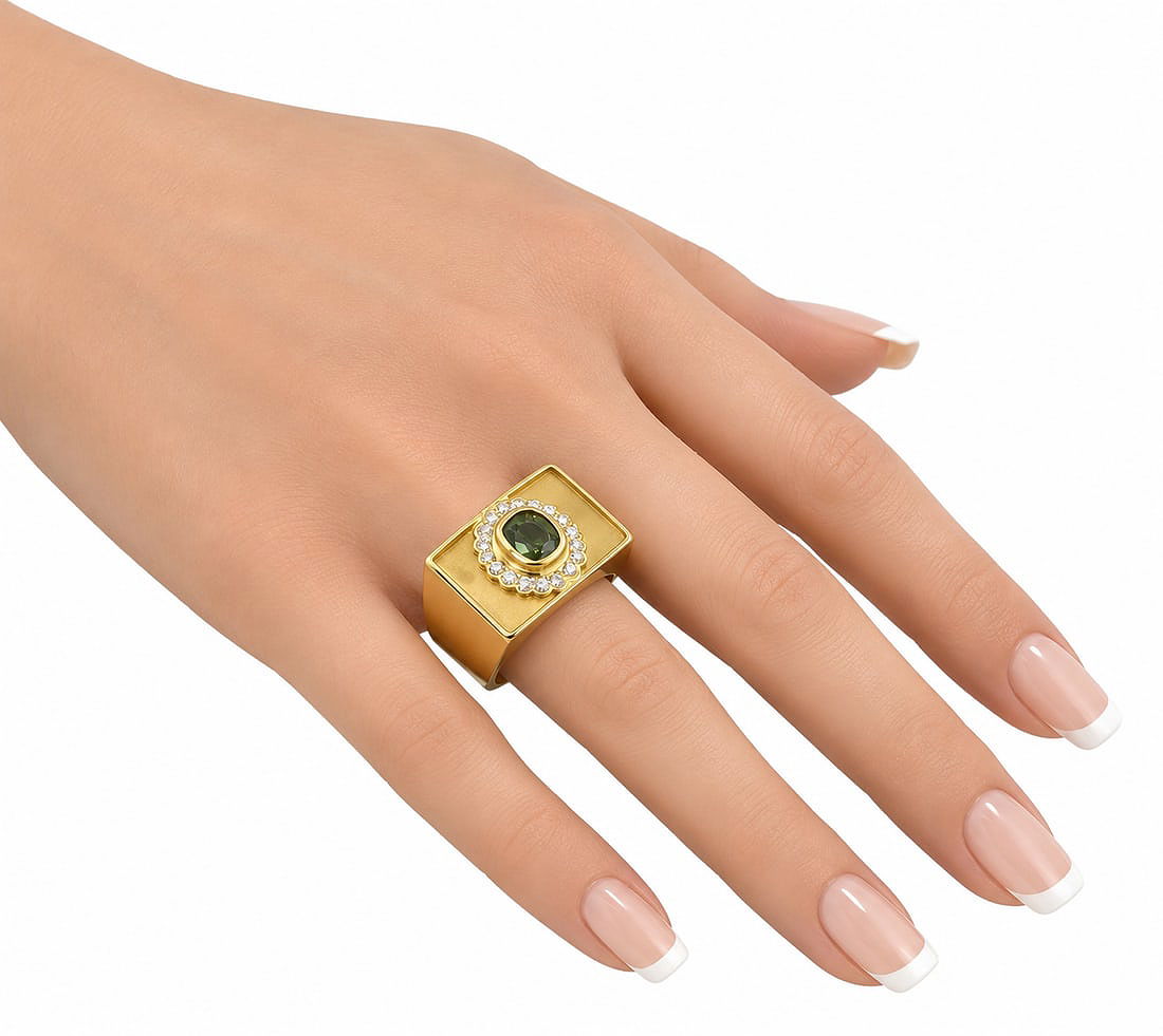 Le Vian 18K yellow gold ring on hand with green center stone and diamond halo