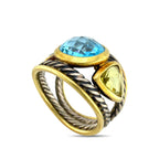 Gold and silver ring with oval blue topaz center stone and twisted braided bands