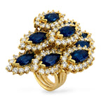 18K yellow gold cocktail ring with oval blue sapphire cluster and diamond halo details