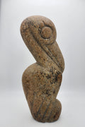 Stone pelican statue, seated form with textured speckled surface and carved beak