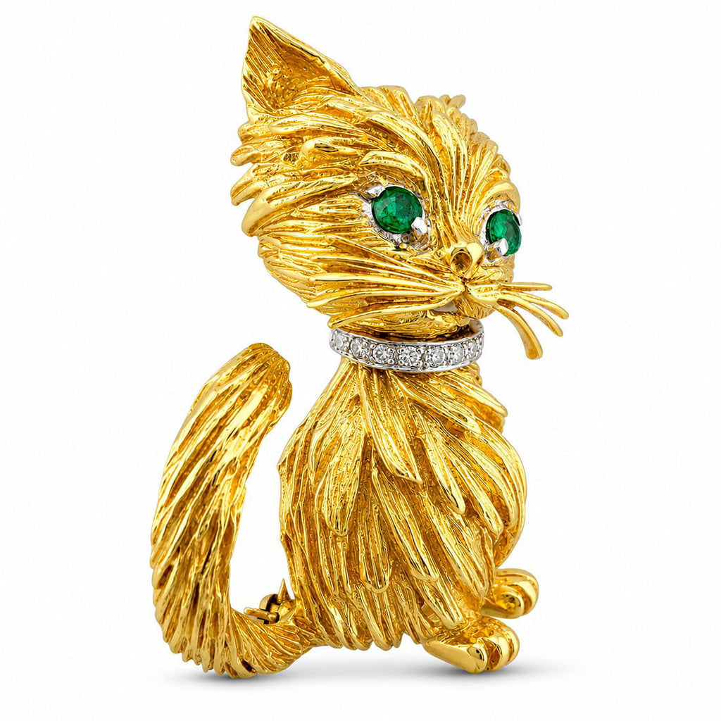 Textured yellow gold cat brooch with emerald eyes and diamond-like collar