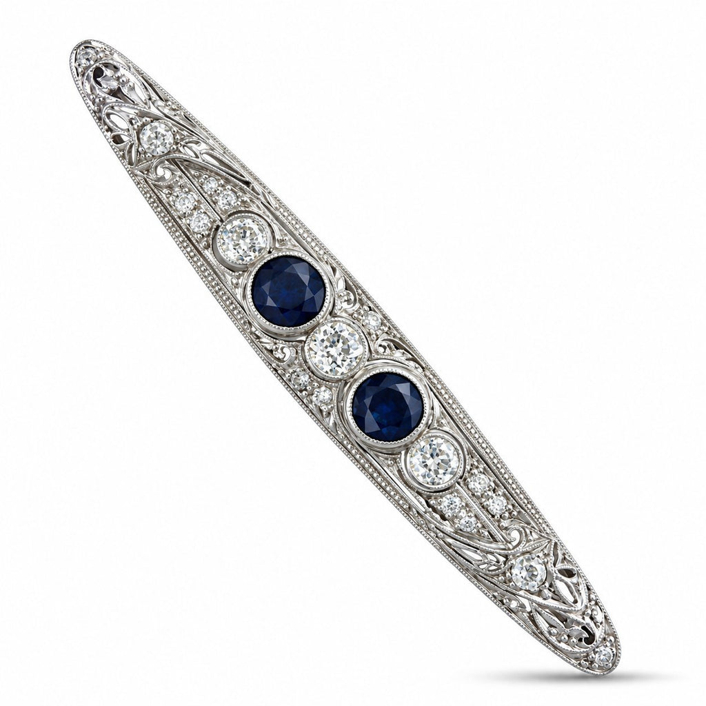Art deco platinum brooch with two blue sapphires and diamond halo accents, bar pin