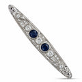 Art deco platinum brooch with two blue sapphires and diamond halo accents, bar pin