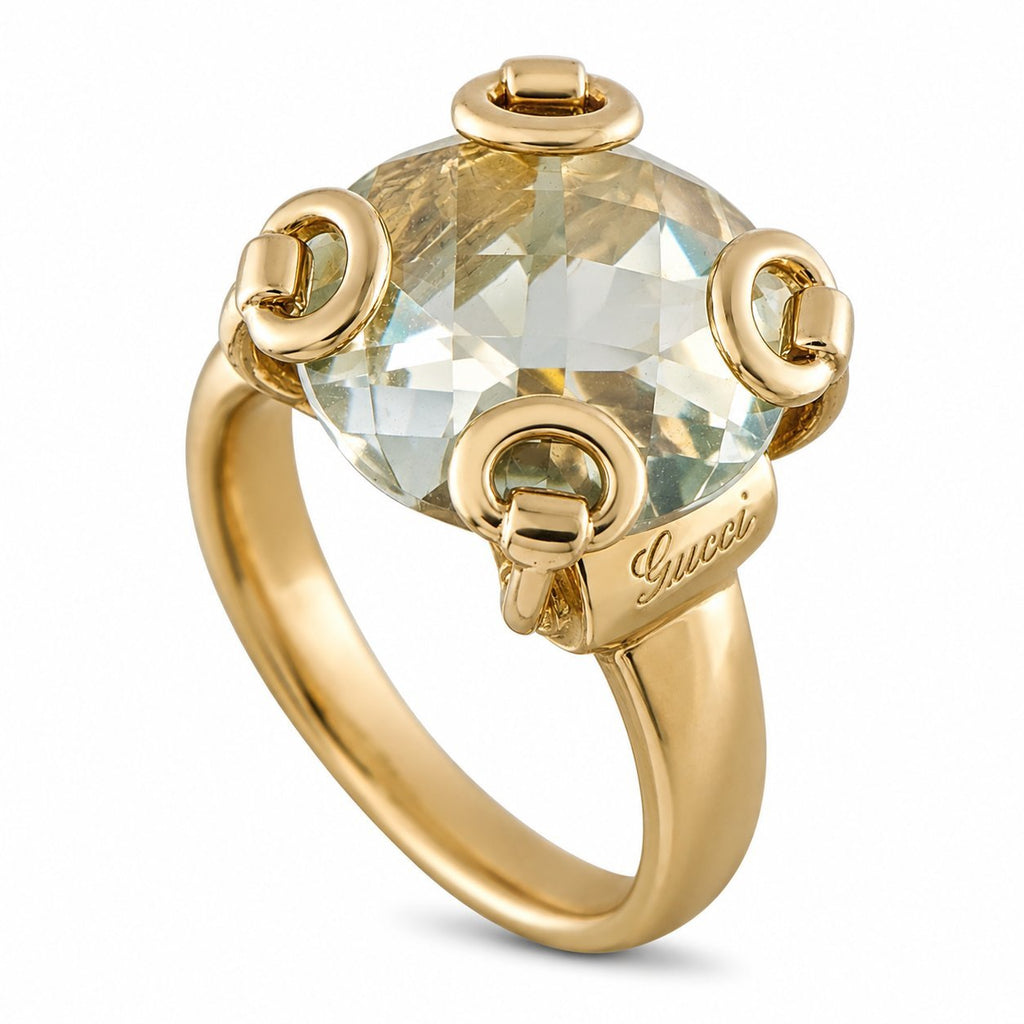 Yellow gold ring with large oval clear topaz centerpiece and horsebit studs, Gucci script