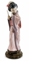 Geisha girl figurine with pink kimono, black hair ornament, holding a fan