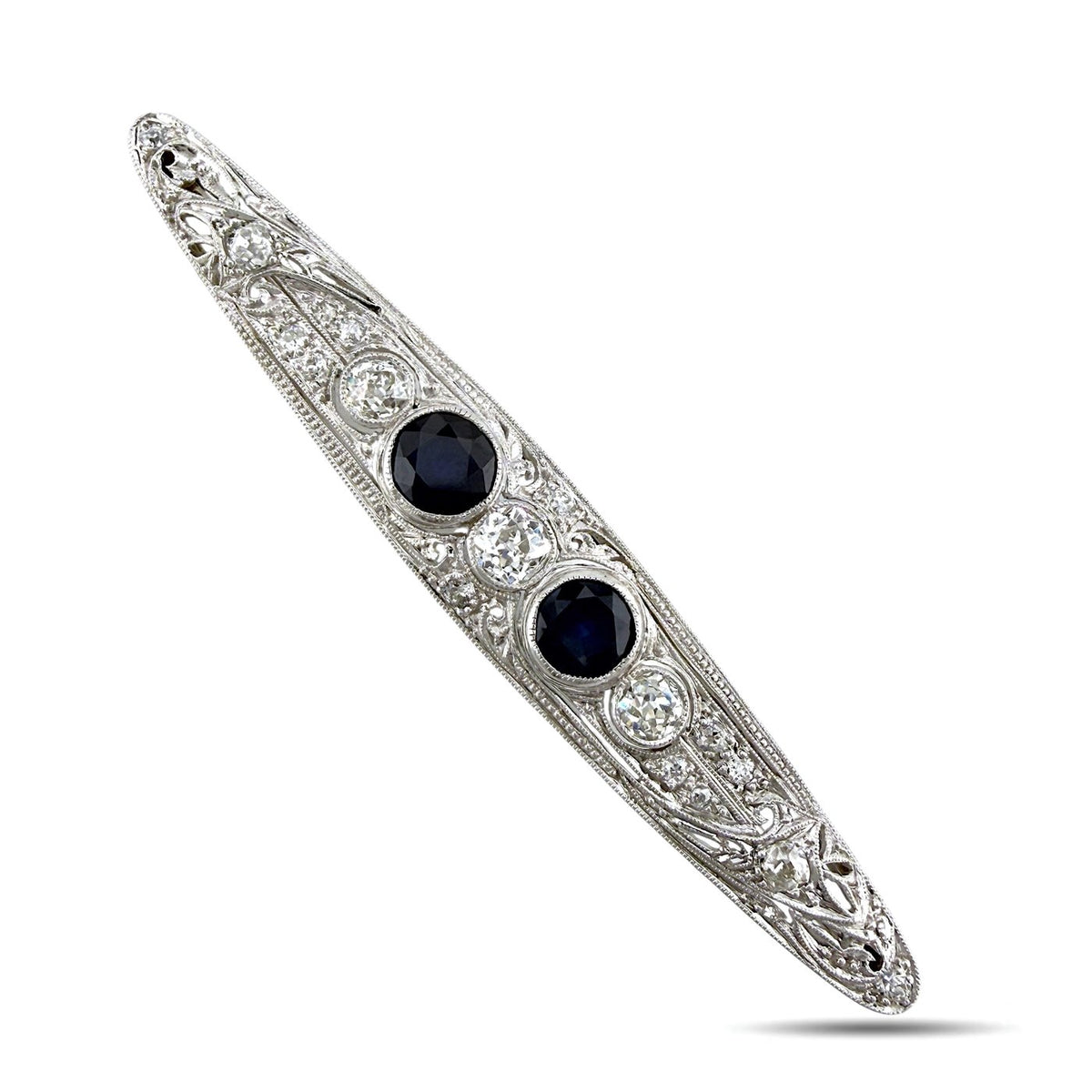 Art deco platinum brooch angled view with two dark blue sapphires and diamond accents