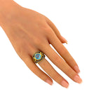 Blue topaz and yellow gemstone ring on finger with gold bezel and braided silver band