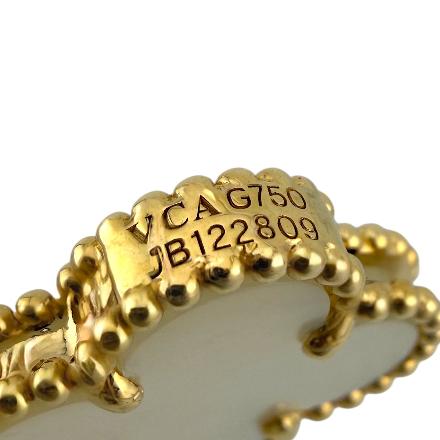 18k gold necklace clasp close-up with engraved serial markings on inner band