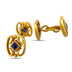 Gold sapphire cufflinks showing the hinged bar fasteners and ornate fronts