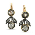 Gold tone diamond drop earrings with three round clear stones in dark settings