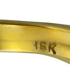 Close-up of 18K hallmark on glossy yellow gold ring band