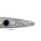 Art deco platinum brooch profile with dark blue sapphire center stone and diamond trim