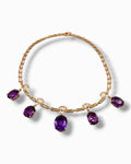 Gold tone necklace with oval amethyst purple gemstones on a linked chain with small drops