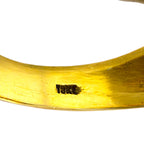 Close-up of inside yellow gold band showing '18K' stamp on polished surface