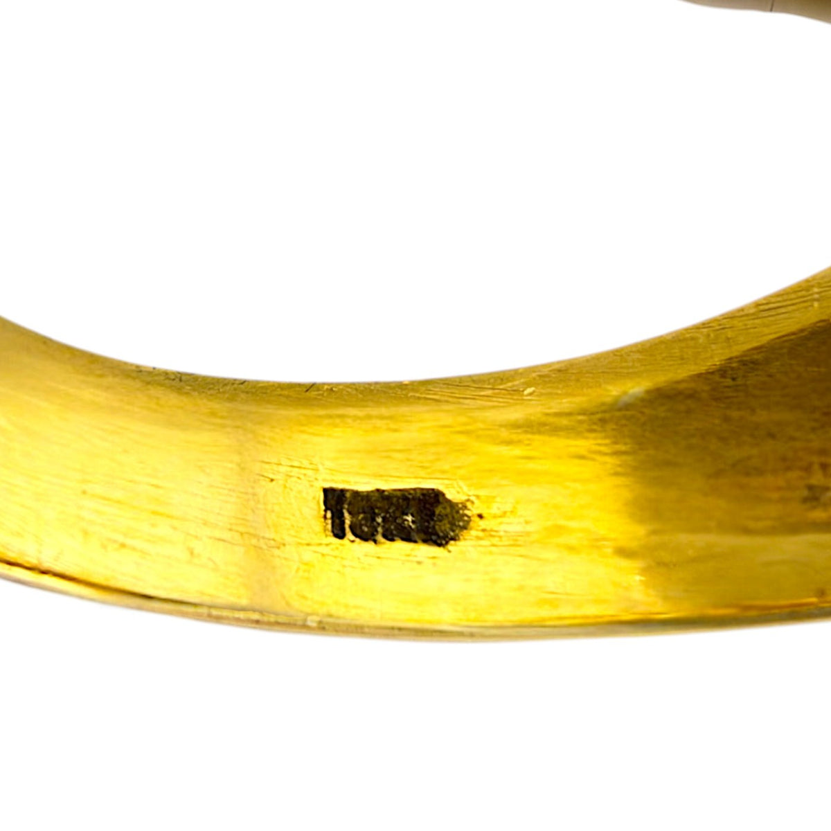 Close-up of inside yellow gold band showing '18K' stamp on polished surface