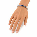 Platinum sapphire tennis bracelet on hand, blue stones on a thin silver band