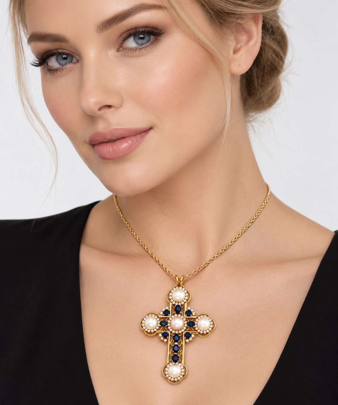 Gold cross pendant necklace with pearl center and blue sapphire and diamond detailing