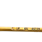 Close-up of the brooch's gold pin with engraved hallmarks