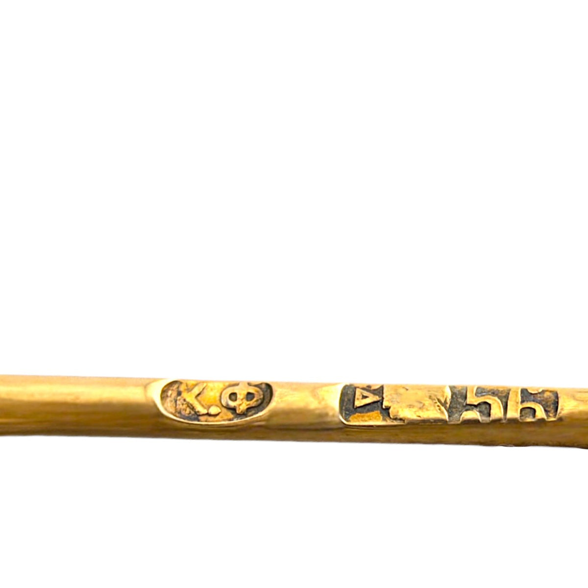 Close-up of the brooch's gold pin with engraved hallmarks