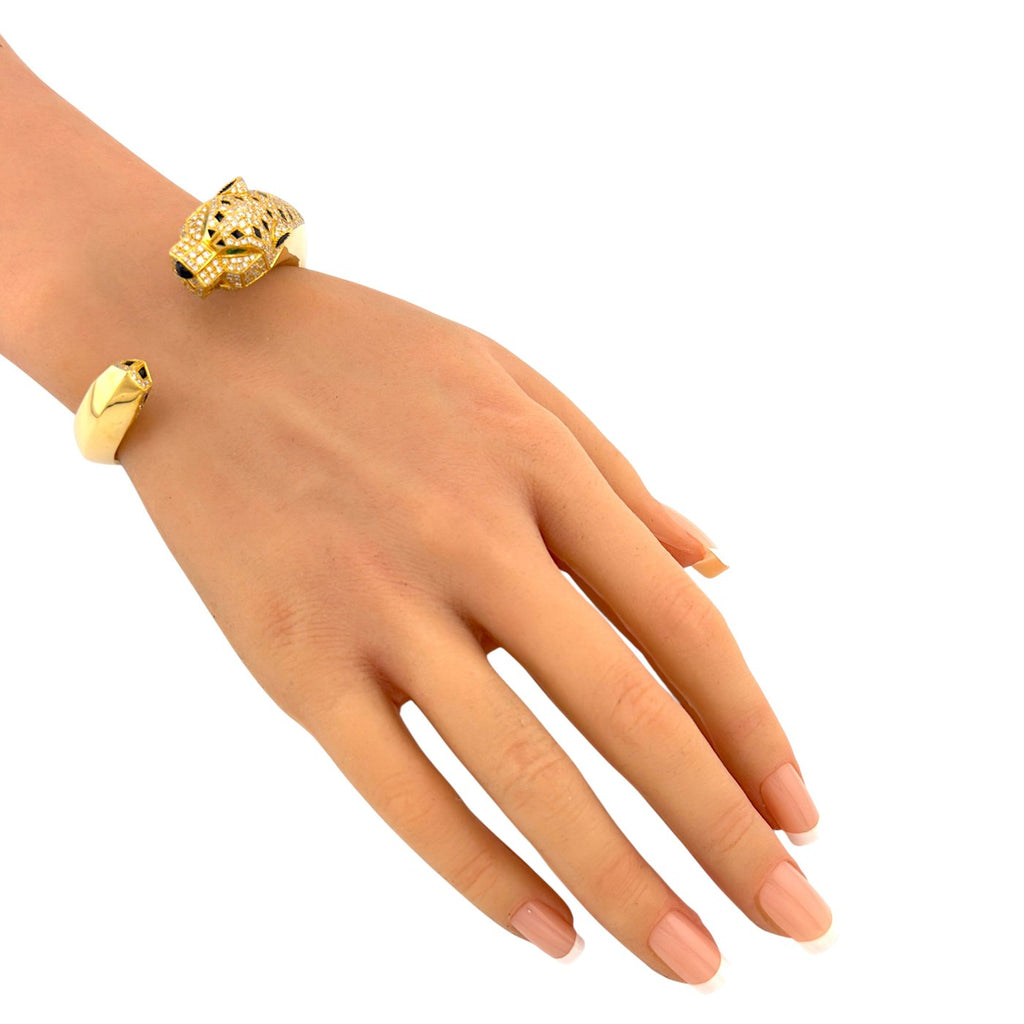Cartier Panthère de Cartier gold bangle with diamond panther head on a wrist