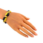 Gold, black onyx, and diamond bracelet worn around the wrist