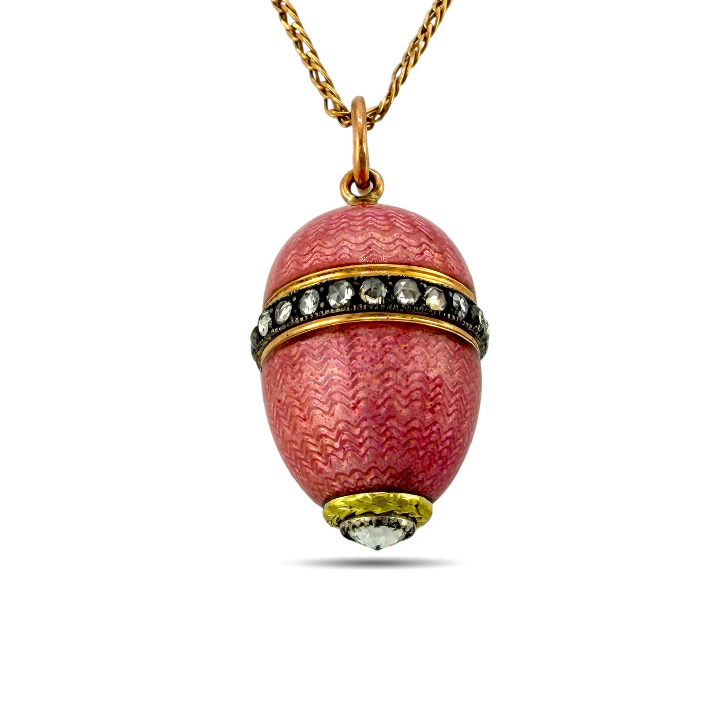 Pink enamel egg pendant with gold tone cap, sparkling stone band, and bottom crystal drop.