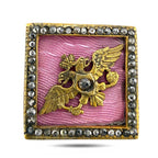 Square pink enamel cufflink face with gold bird-and-animal motif and rhinestone border