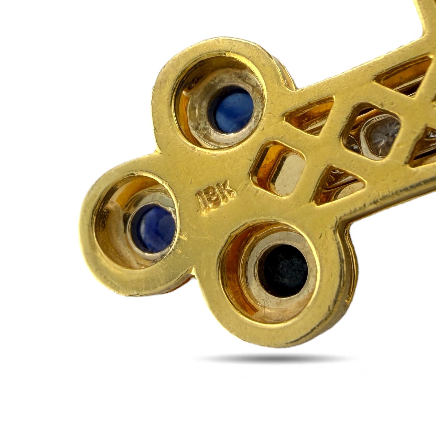Back of gold cross pendant with blue sapphire settings and stamped markings